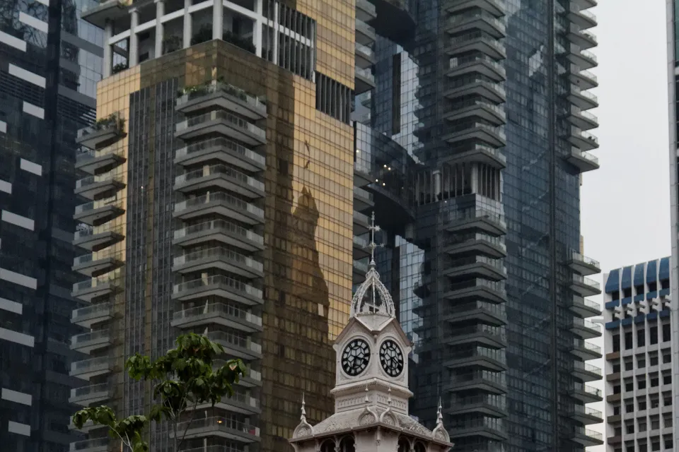 The clock tower and cast iron roof of Lau Pa Sat in Singapore, cropped above the street sign