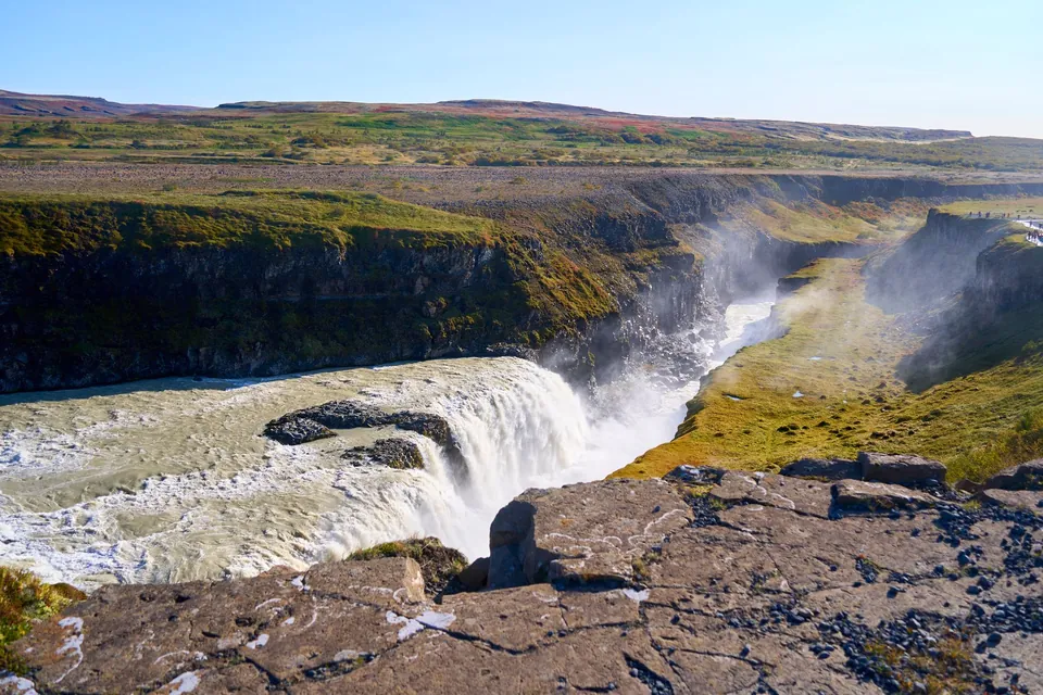 Gullfoss waterfall plunging into a rocky canyon under a clear blue sky