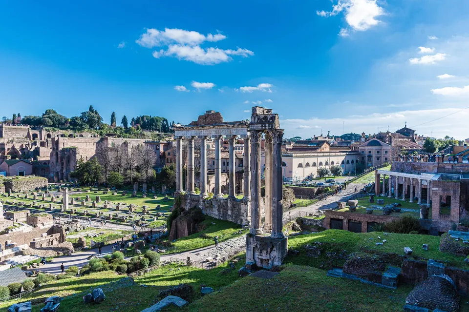 Columns and ruins of the Roman Forum in Rome under a clear blue sky