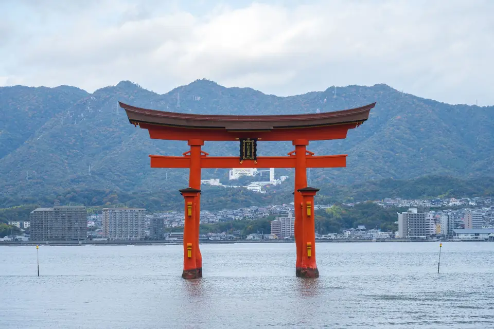 The floating torii gate of Itsukushima Shrine on Miyajima, with mountains behind