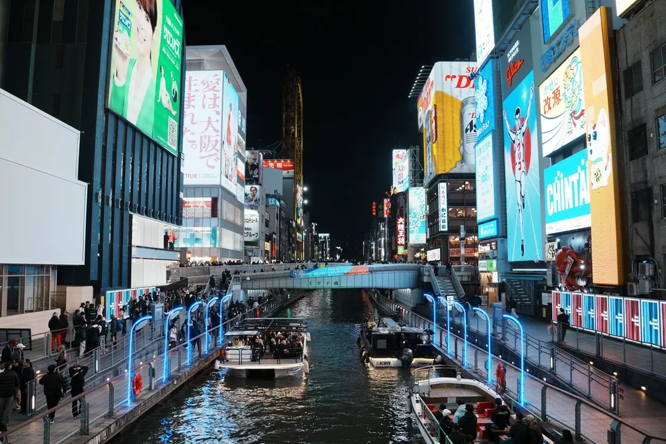 Neon signs and crowds along the Dotonbori canal in Osaka at night