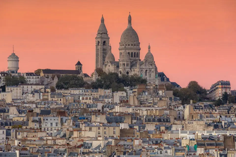 Sacré-Cœur on the hill of Montmartre above the Paris rooftops at dusk