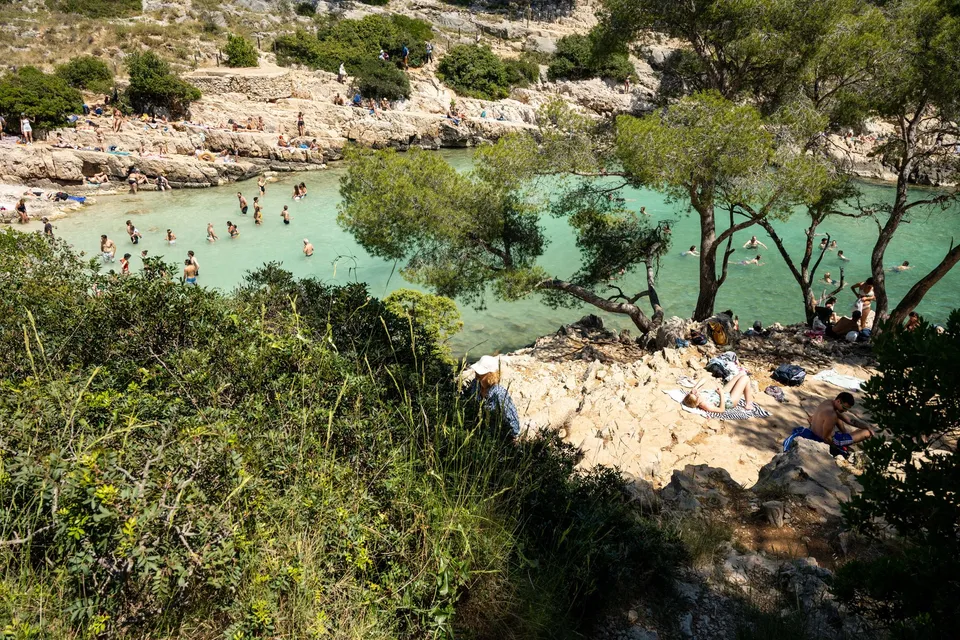 Swimmers in the turquoise cove of the Calanque de Sugiton near Marseille