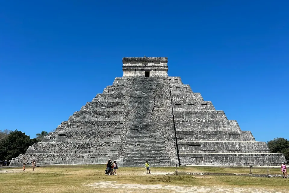 El Castillo, the great pyramid of Chichen Itza, with visitors on the lawn in front
