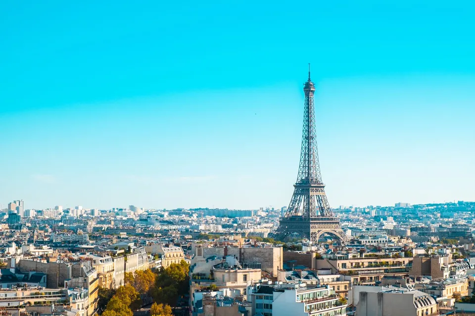 The Eiffel Tower rising above the rooftops of Paris on a clear day