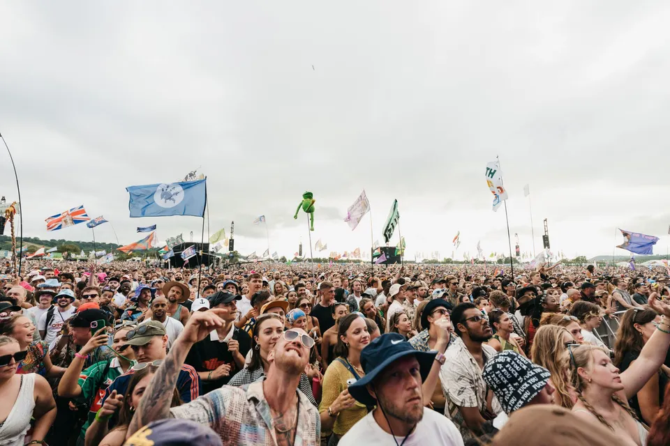 A crowd under festival flags at Glastonbury