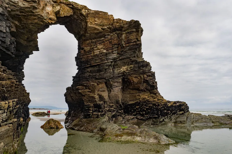 A rock arch at low tide on Las Catedrales beach in Galicia