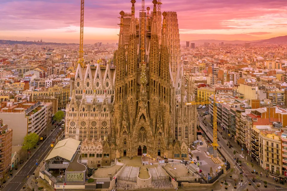 The Sagrada Familia from the air at sunset, rising above the streets of Barcelona